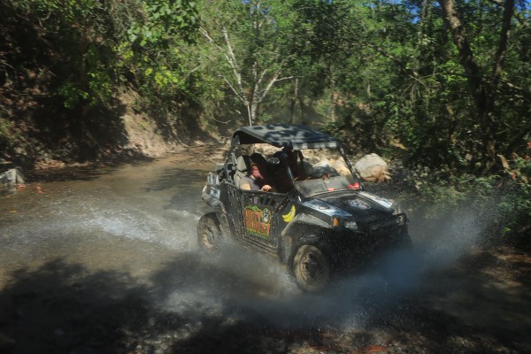 Young person riding a motorcycle in an adventurous landscape, enjoying an exciting outdoor activity in Puerto Vallarta with a RZR