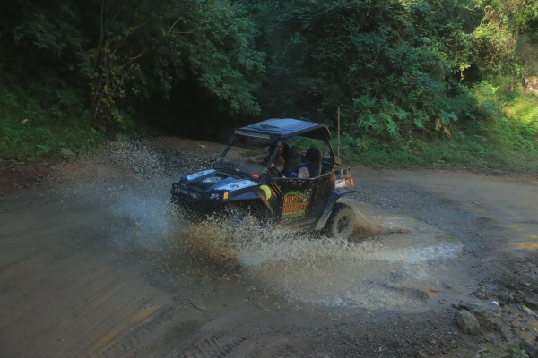 UTV crossing a powerful river, showcasing its off-road capability on challenging terrain, perfect for adventurous UTV experiences.
